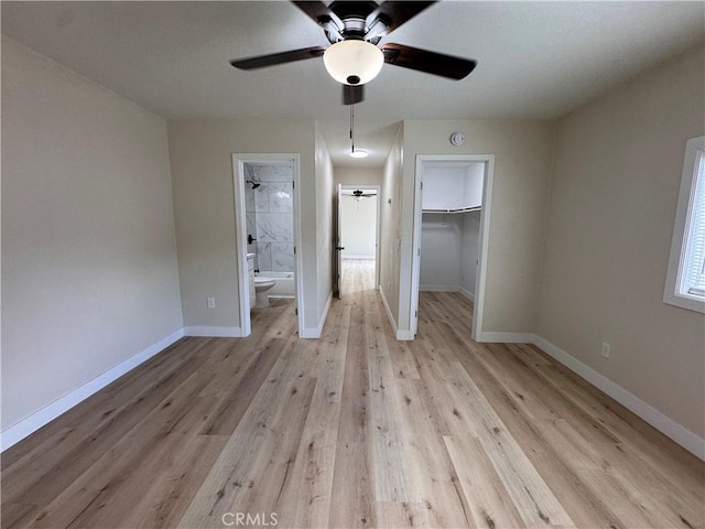 1716 Paloma St, Barstow, CA 92311 - unfurnished bedroom with a walk in closet, light wood finished floors, and baseboards