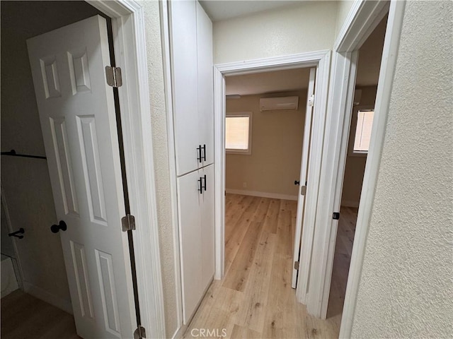 1716 Paloma St, Barstow, CA 92311 - hallway featuring a wall mounted AC, light wood-type flooring, baseboards, and a textured wall