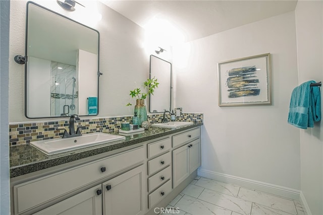 bathroom with baseboards, a sink, marble finish floor, and a shower stall