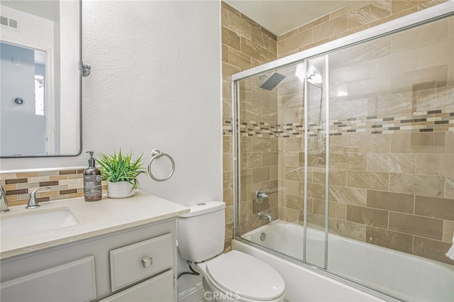 bathroom featuring shower / bath combination with glass door, vanity, toilet, backsplash, and visible vents