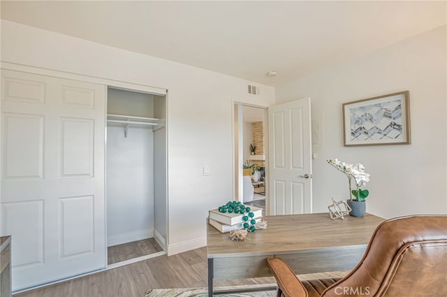 office space with visible vents, baseboards, and wood finished floors