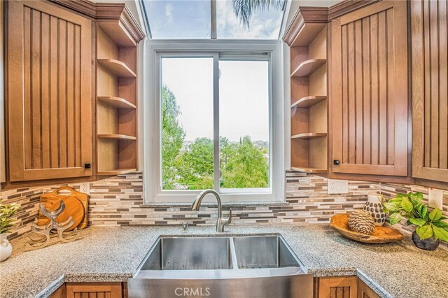 kitchen featuring a sink, open shelves, and tasteful backsplash