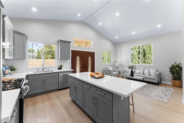 17841 Buena Vista Ave, Yorba Linda, CA 92886 - kitchen with stainless steel appliances, gray cabinetry, a kitchen island, high vaulted ceiling, and light countertops