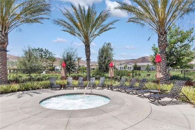view of pool featuring fence and a community hot tub