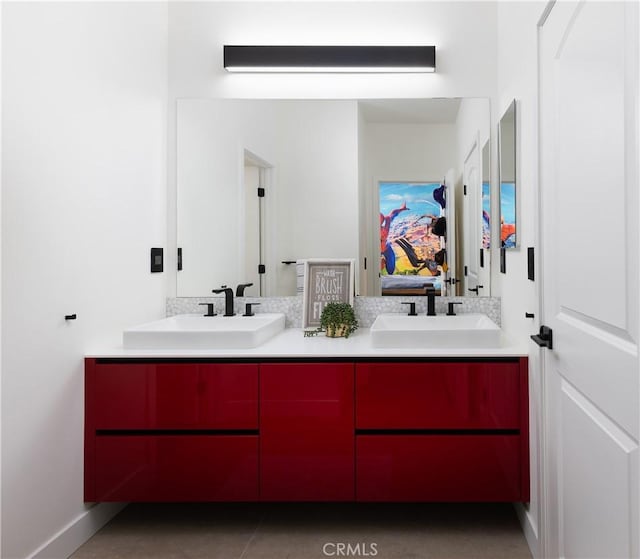 ensuite bathroom with double vanity, baseboards, ensuite bathroom, and a sink