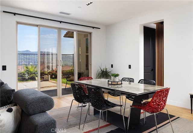 dining space featuring light wood-type flooring and visible vents