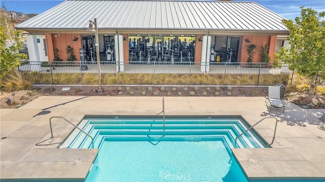 view of swimming pool featuring a patio area, a swimming pool, and fence