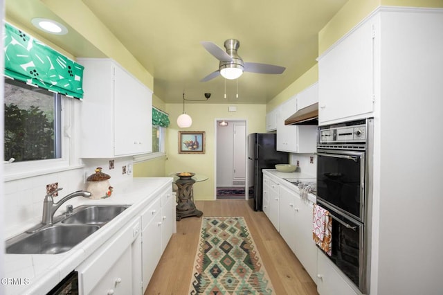 675 Mount Wilson Trl, Sierra Madre, CA 91024 - kitchen with a sink, under cabinet range hood, white cabinetry, light countertops, and black appliances