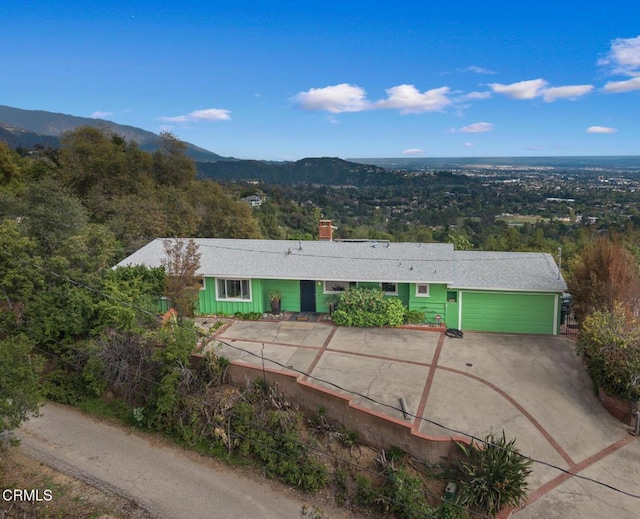 675 Mount Wilson Trl, Sierra Madre, CA 91024 - view of front of house featuring a garage, concrete driveway, a chimney, and a mountain view