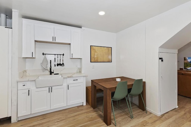 331 W Sherwood Blvd, Big Bear City, CA 92314 - kitchen featuring white cabinetry, a sink, light stone countertops, and light wood finished floors
