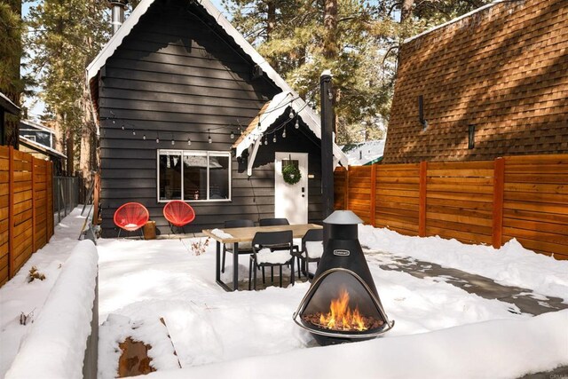 331 W Sherwood Blvd, Big Bear City, CA 92314 - snow covered patio featuring an outdoor fire pit, a fenced backyard, and outdoor dining area