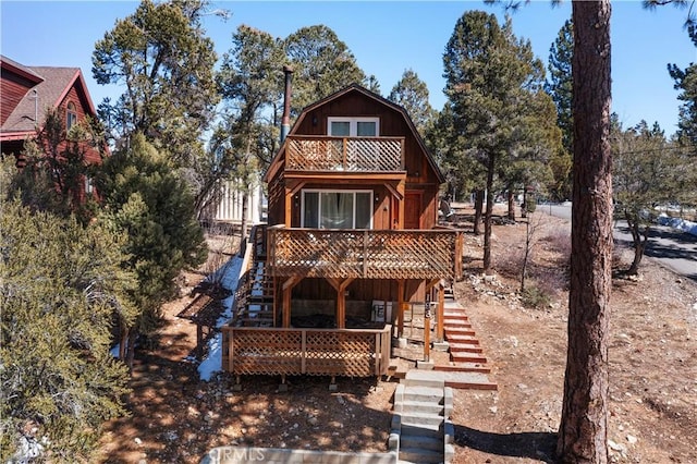 193 Riverside Ave, Sugarloaf, CA 92386 - back of house featuring a gambrel roof, a balcony, stairs, and a wooden deck