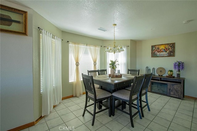 7469 Madera Ave, Hesperia, CA 92345 - dining space featuring a textured ceiling, light tile patterned flooring, baseboards, visible vents, and an inviting chandelier