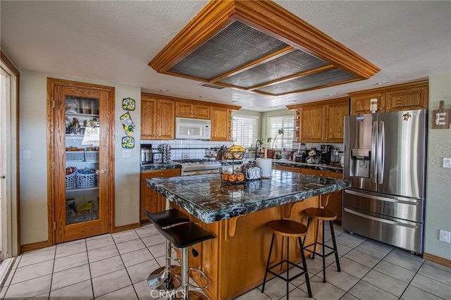 7469 Madera Ave, Hesperia, CA 92345 - kitchen featuring tasteful backsplash, tile countertops, light tile patterned flooring, white appliances, and a kitchen island