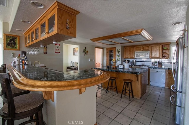 7469 Madera Ave, Hesperia, CA 92345 - interior space with open shelves, a breakfast bar, white appliances, a peninsula, and a textured ceiling