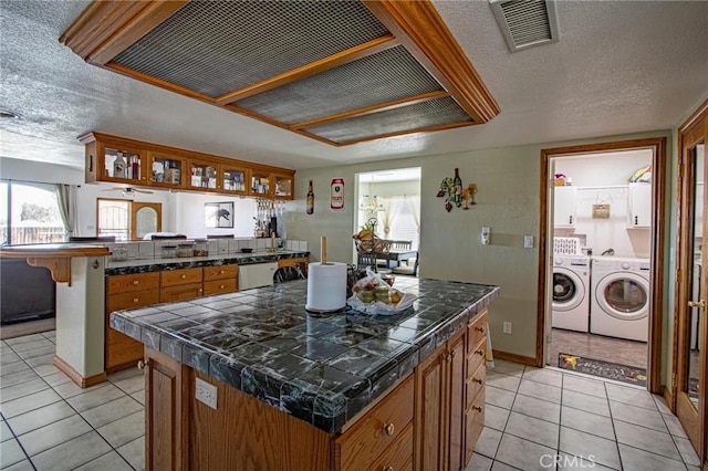 7469 Madera Ave, Hesperia, CA 92345 - kitchen featuring separate washer and dryer, ventilation hood, visible vents, and tile countertops