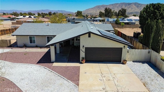 7469 Madera Ave, Hesperia, CA 92345 - ranch-style house featuring solar panels, driveway, a fenced backyard, and stucco siding