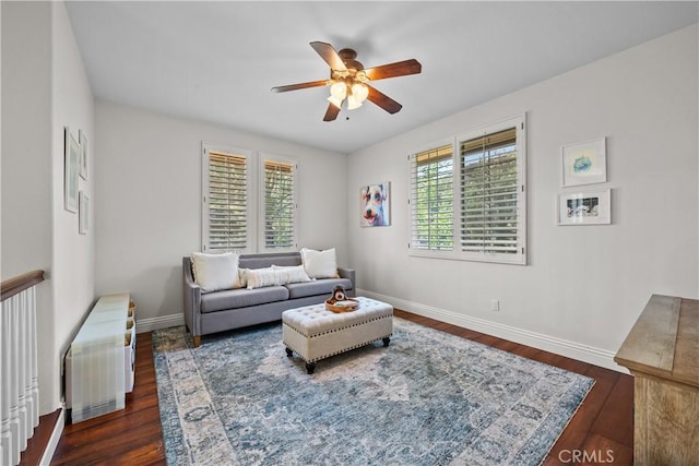 living area featuring a ceiling fan, healthy amount of natural light, wood finished floors, and baseboards