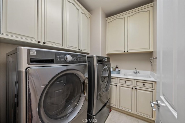 laundry room featuring cabinet space, washer and clothes dryer, and light tile patterned floors