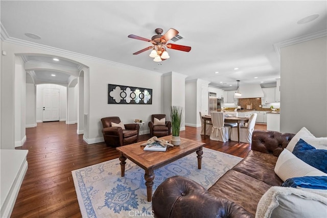 living room featuring ceiling fan, recessed lighting, dark wood-style floors, arched walkways, and baseboards