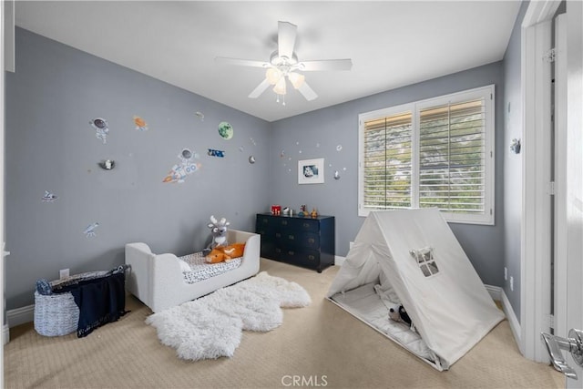 carpeted bedroom featuring baseboards and a ceiling fan