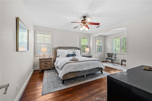 bedroom with baseboards, dark wood-style floors, and a ceiling fan