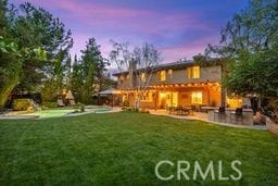 back of house with a patio and a yard