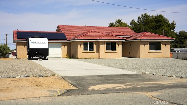 14610 Appleton St, Hesperia, CA 92345 - view of front of property featuring a garage, concrete driveway, roof mounted solar panels, and stucco siding