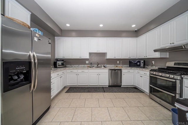 3567 Boussock Ln, Oceanside, CA 92057 - kitchen with under cabinet range hood, white cabinets, a sink, light tile patterned floors, and stainless steel appliances