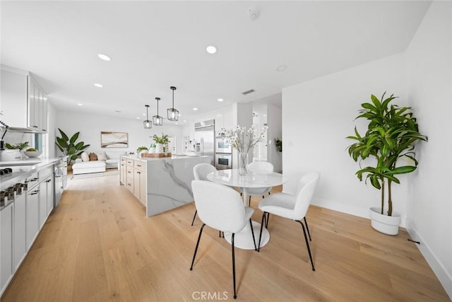 dining area with recessed lighting, visible vents, light wood-style flooring, and baseboards