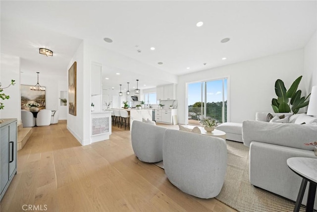 living area featuring light wood-type flooring and recessed lighting