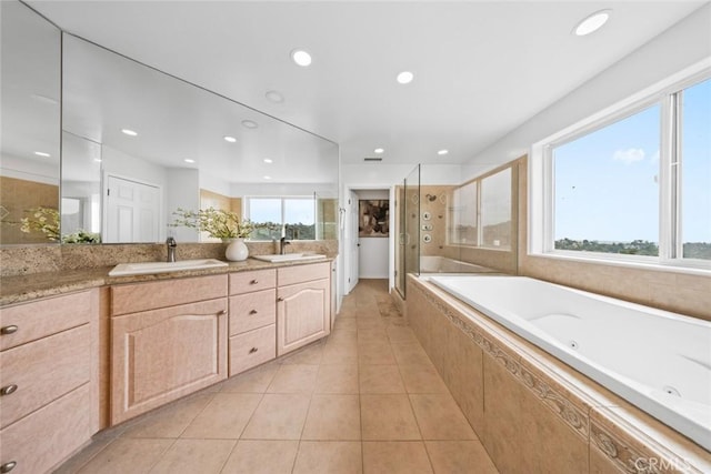 full bath with a shower stall, tile patterned flooring, double vanity, and a sink