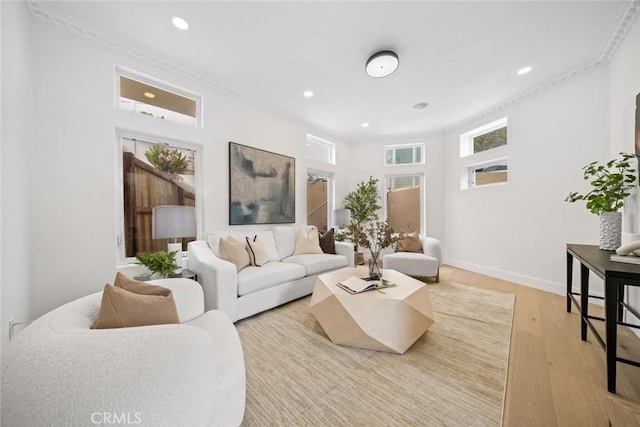 living area featuring crown molding, light wood finished floors, recessed lighting, and baseboards