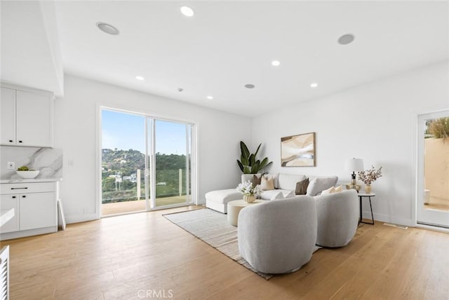 living room with recessed lighting, visible vents, and light wood-style flooring