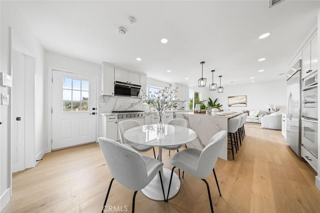 dining space with recessed lighting and light wood-style floors