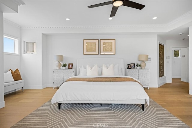 bedroom featuring light wood-type flooring, ornamental molding, and baseboards