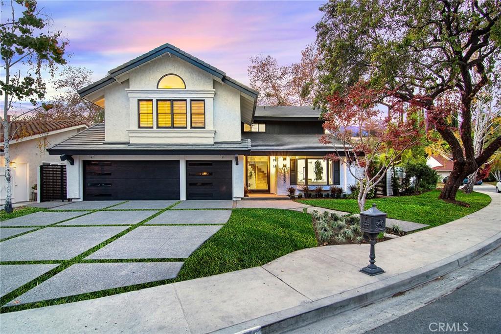 view of front of home with stucco siding, concrete driveway, a garage, and a lawn