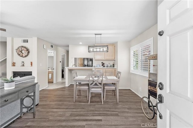 dining room featuring baseboards, visible vents, and wood finished floors