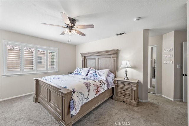 bedroom with light carpet, baseboards, visible vents, and ceiling fan
