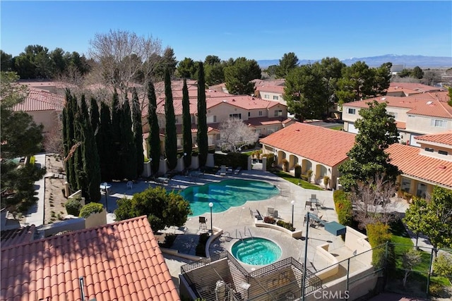 pool with a residential view, a hot tub, fence, and a patio area