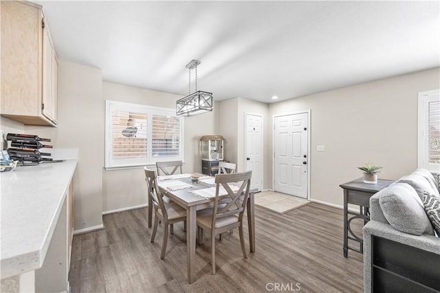 dining area with baseboards and light wood finished floors
