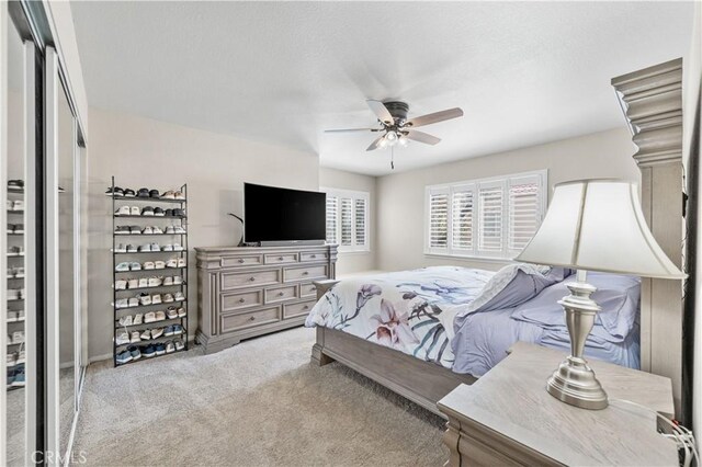 carpeted bedroom featuring a textured ceiling and ceiling fan