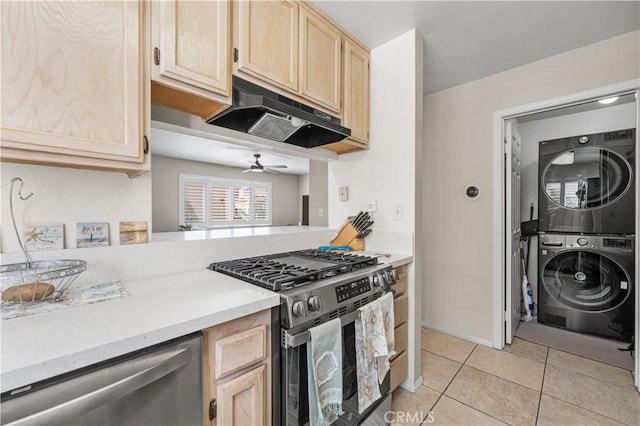 kitchen with light tile patterned flooring, appliances with stainless steel finishes, under cabinet range hood, stacked washing maching and dryer, and light brown cabinetry