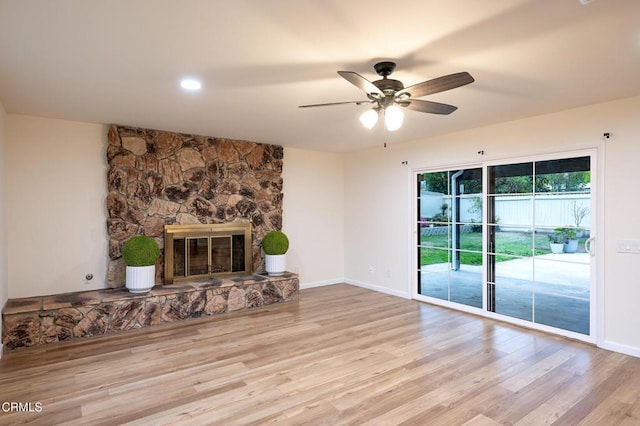 unfurnished living room with baseboards, a fireplace, wood finished floors, and a ceiling fan