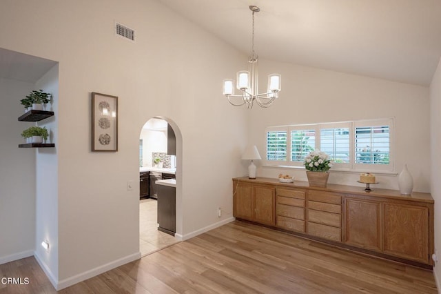 unfurnished dining area featuring high vaulted ceiling, light wood-type flooring, visible vents, arched walkways, and an inviting chandelier