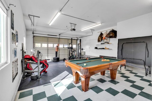 rec room with light floors, billiards, and a garage