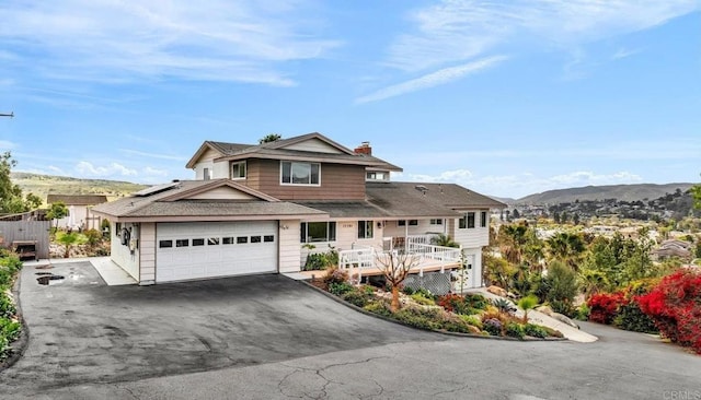 traditional home featuring solar panels, driveway, a chimney, and a mountain view