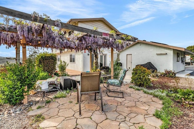 rear view of property with stucco siding, outdoor dining space, and a patio