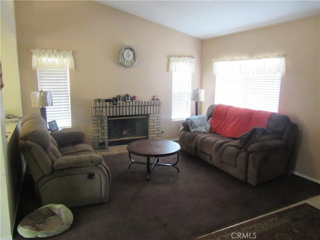 carpeted living area featuring a fireplace, a healthy amount of sunlight, and vaulted ceiling