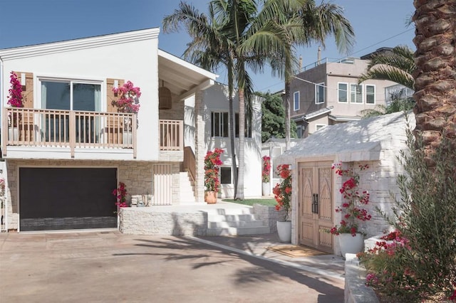 164 Chestnut Ave, Carlsbad, CA 92008 - view of front of home with stairway, an attached garage, stone siding, concrete driveway, and covered porch